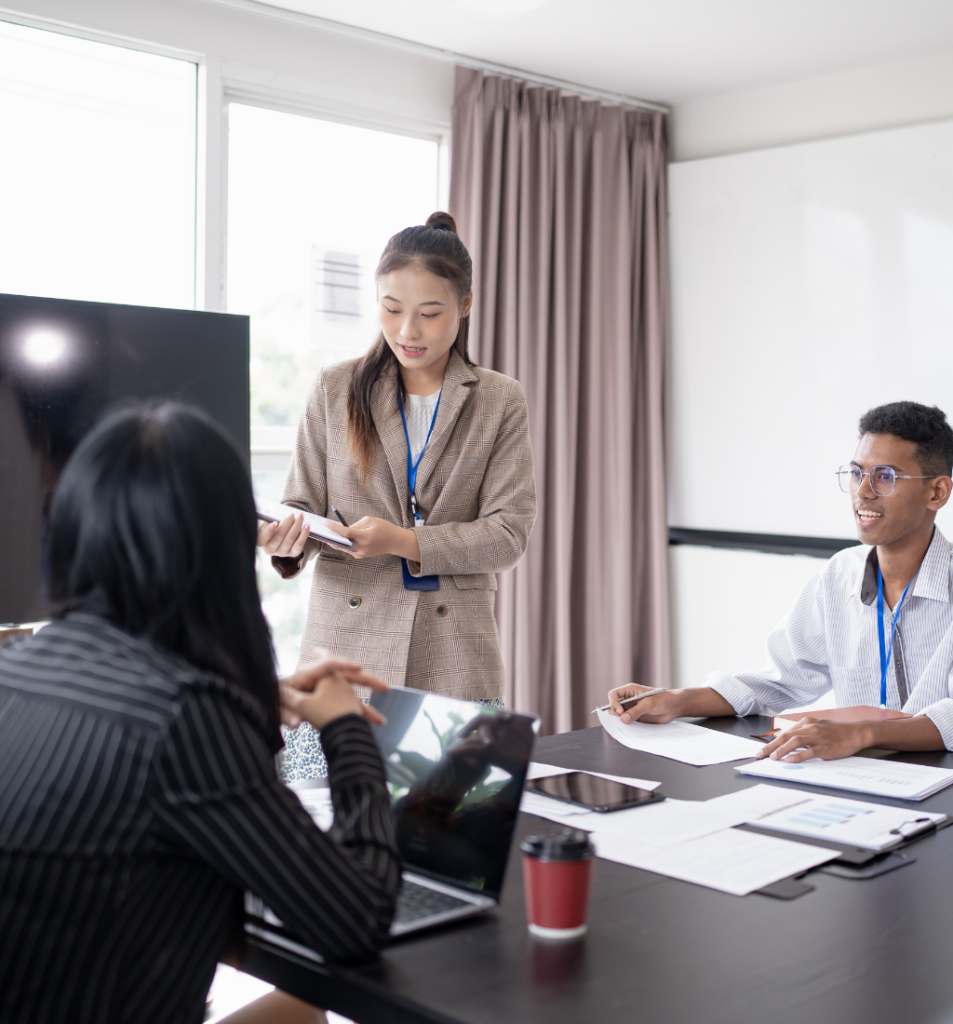 Fractional operations leader guiding a team meeting, reviewing plans and coordinating priorities with staff in a modern office.