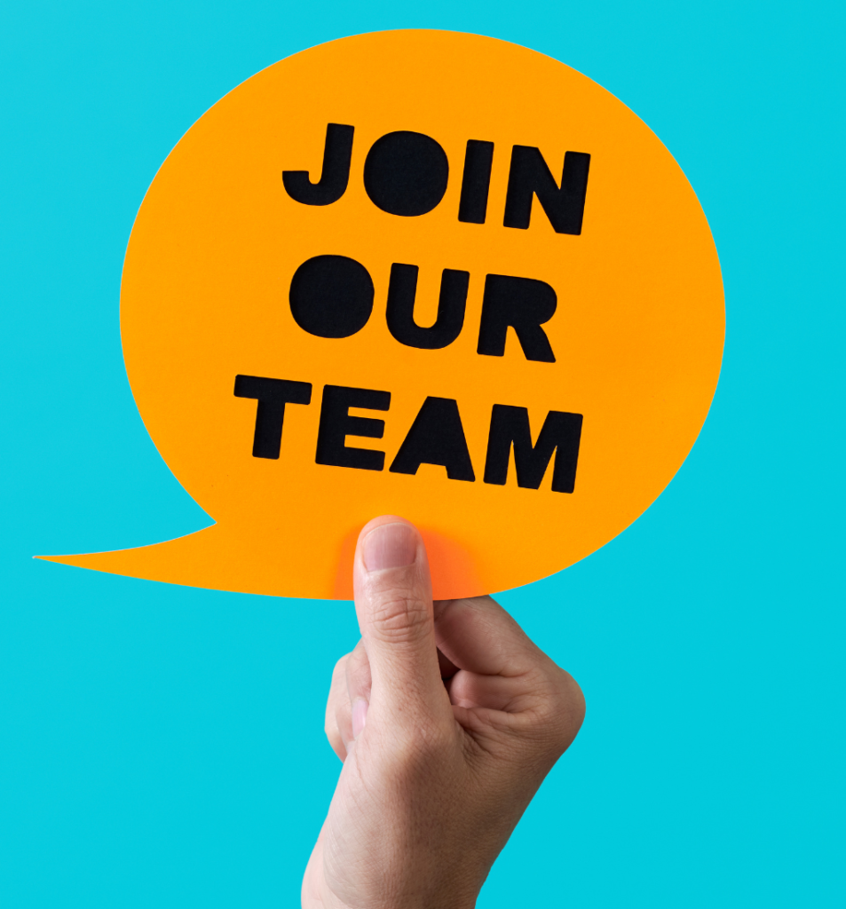 Hand holding a “join our team” sign, representing how to know when to hire for growing business needs.