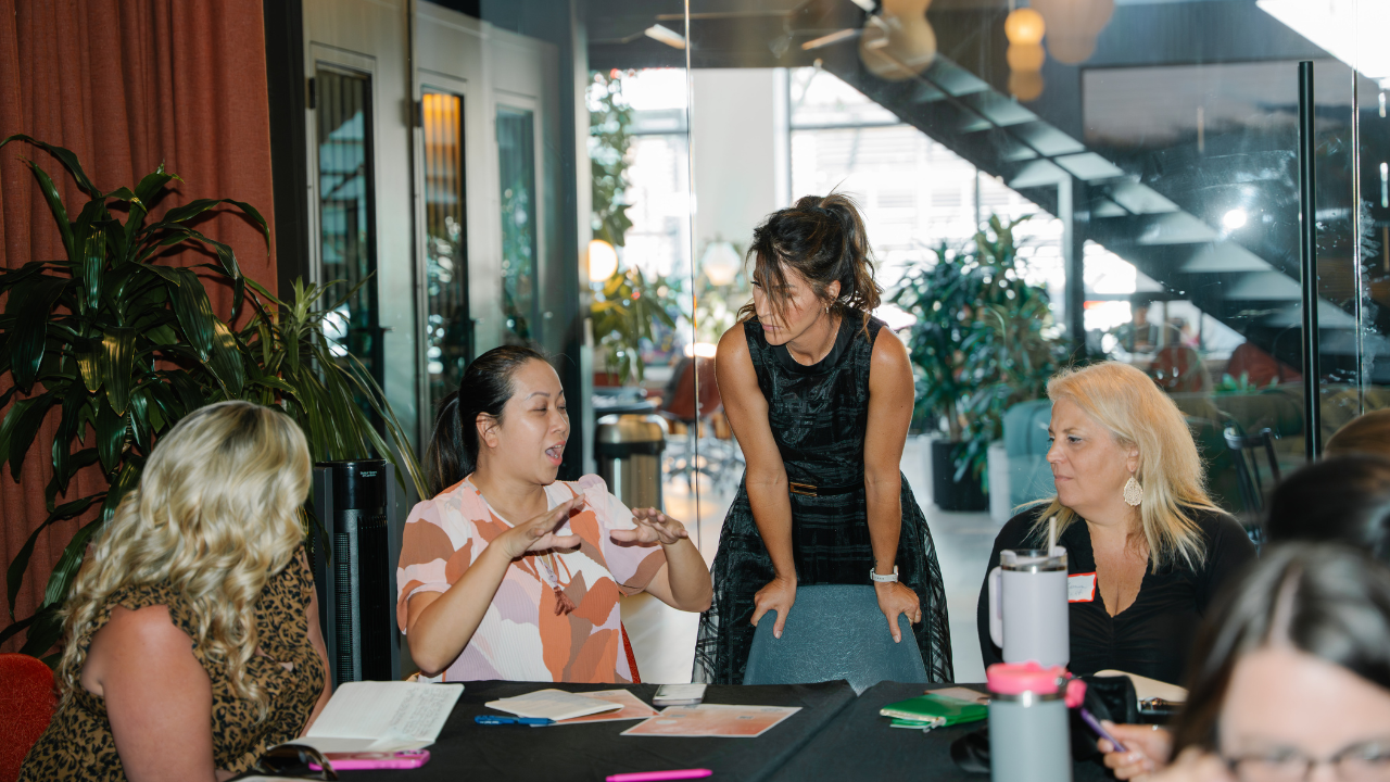 Women in a business meeting discuss ideas and leadership systems to think like an operator.