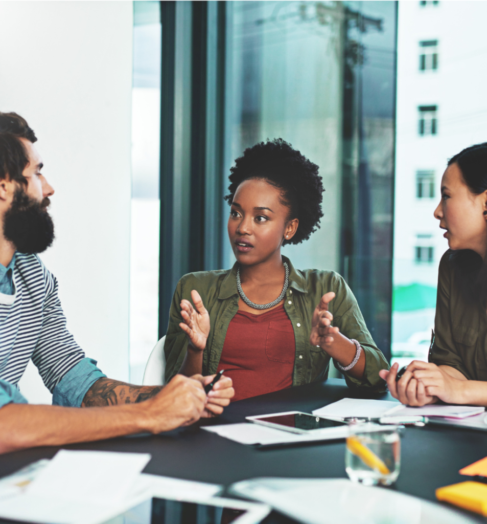 Diverse team discussing ideas around a conference table during collaborative business decision-making.