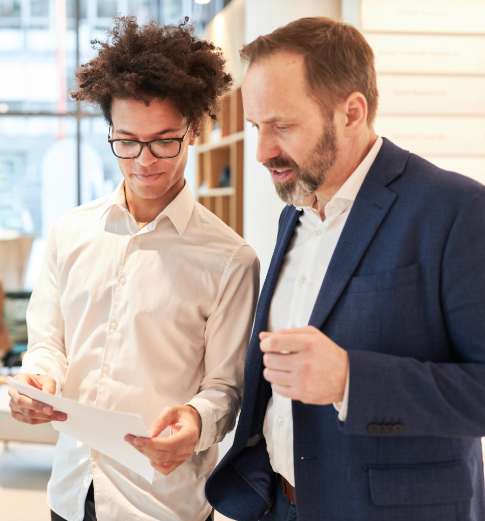 Employee reviewing documents with a business leader, illustrating founder reliance for guidance and approval.