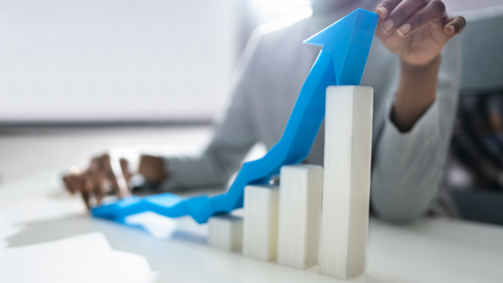 Business professional arranging a rising blue arrow over a bar chart to illustrate the purpose of a sales pipeline.