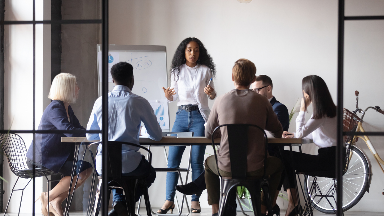 Business team discussing a sales follow-up workflow during a meeting led by a presenter.