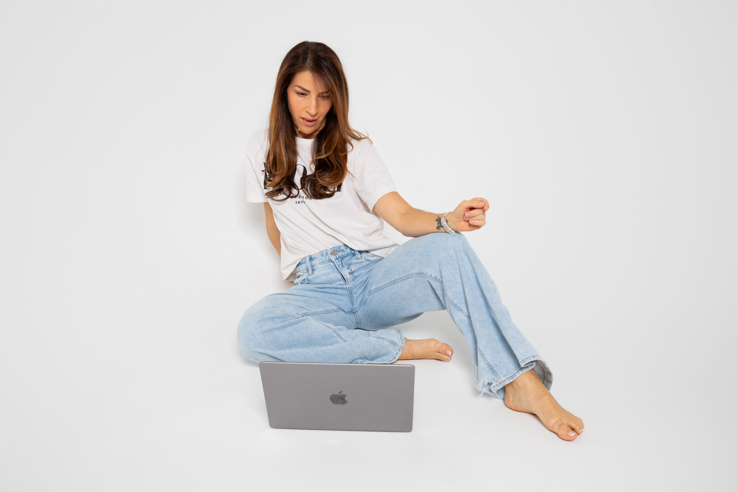 Business system problems shown as a founder sitting on the floor with a laptop, looking concerned while working through operational challenges.