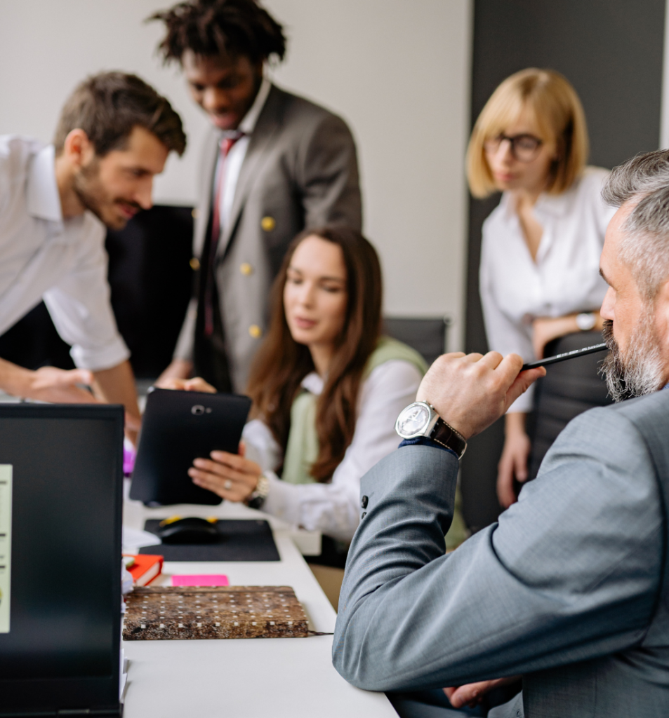 Business team gathers around a desk to discuss tasks and make quick decisions, illustrating reactive business management in a fast-paced workplace.
