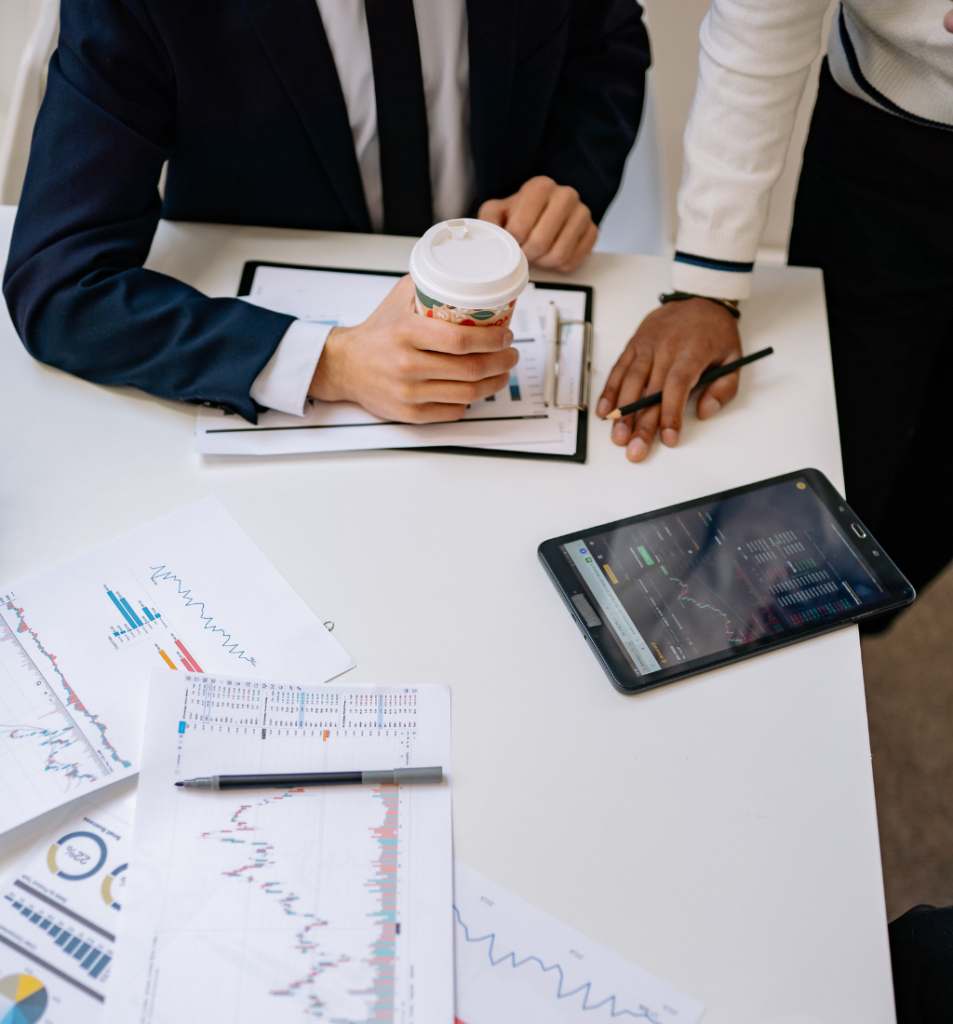 Business professionals reviewing charts and digital data to improve business systems and processes.